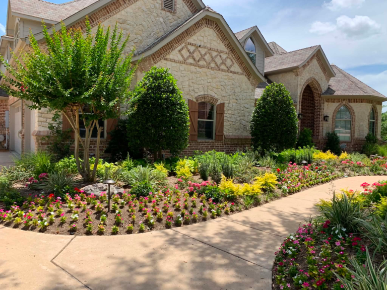 Front yard landscape bed with seasonal flowers, shrubs and a crape myrtle